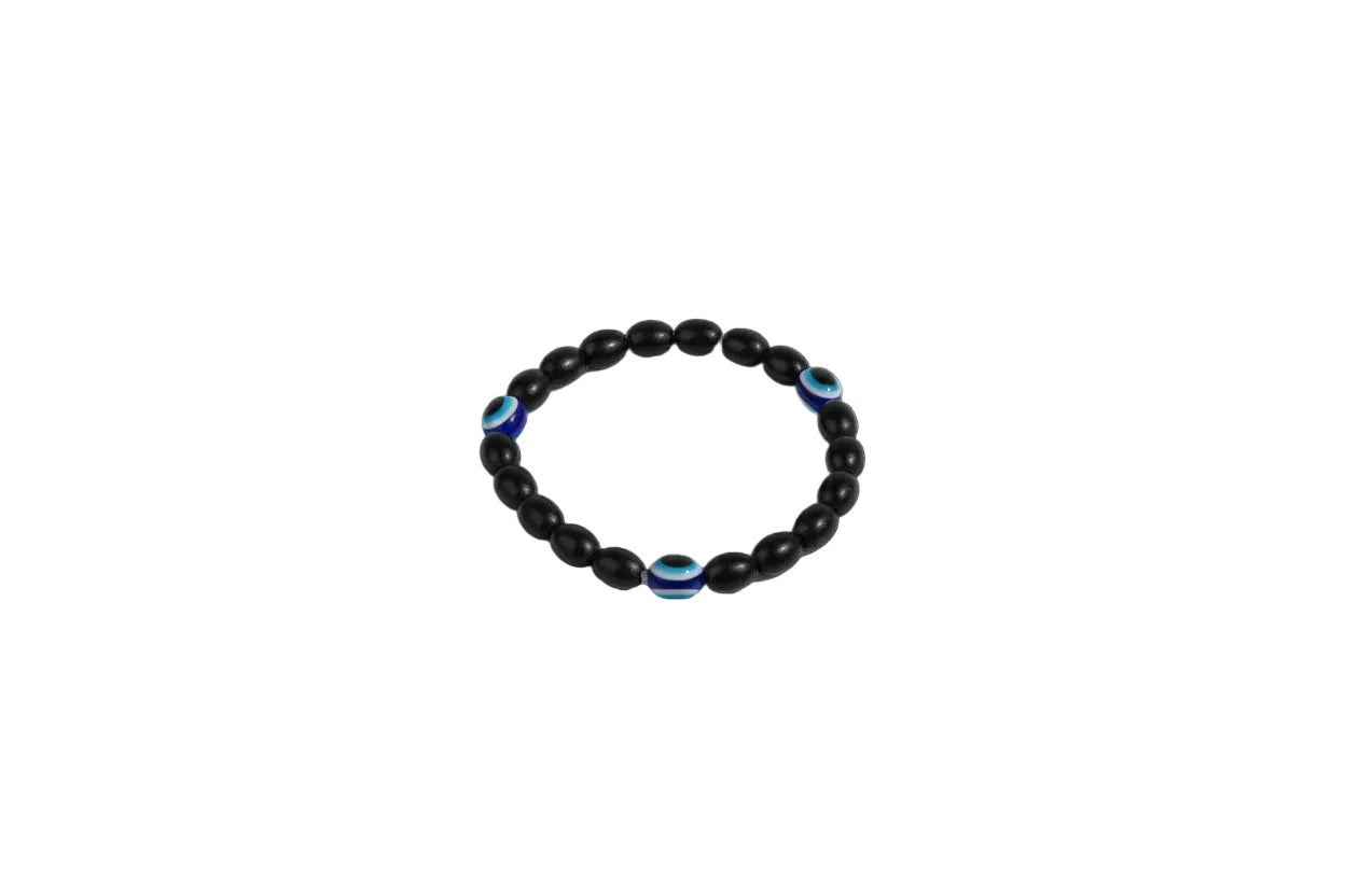 Black beaded bracelet with blue accents on a large green leaf against a red background